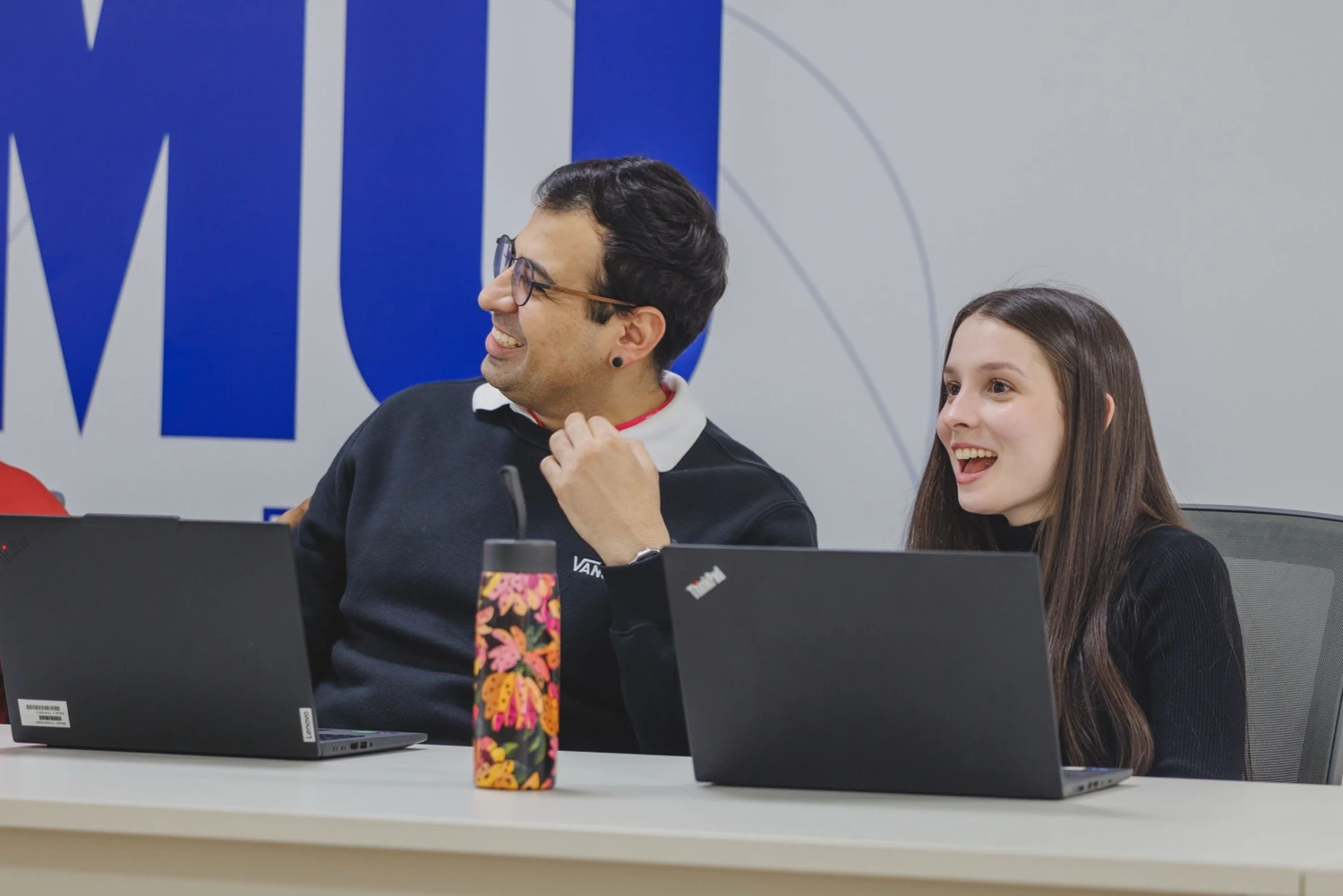 Estagiários da Unilever conversando em frente ao notebook